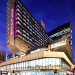 The front of mercure manchester piccadilly hotel at night as seen from piccadilly gardens in manchester