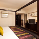 Four poster bed with view into sitting room in a superior room at mercure manchester piccadilly hotel