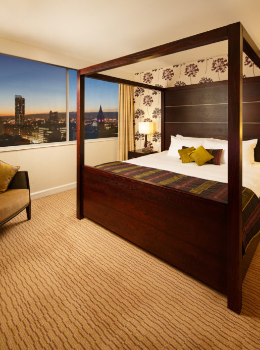 Four poster bed with nighttime picture window view in a superior room at mercure manchester piccadilly hotel