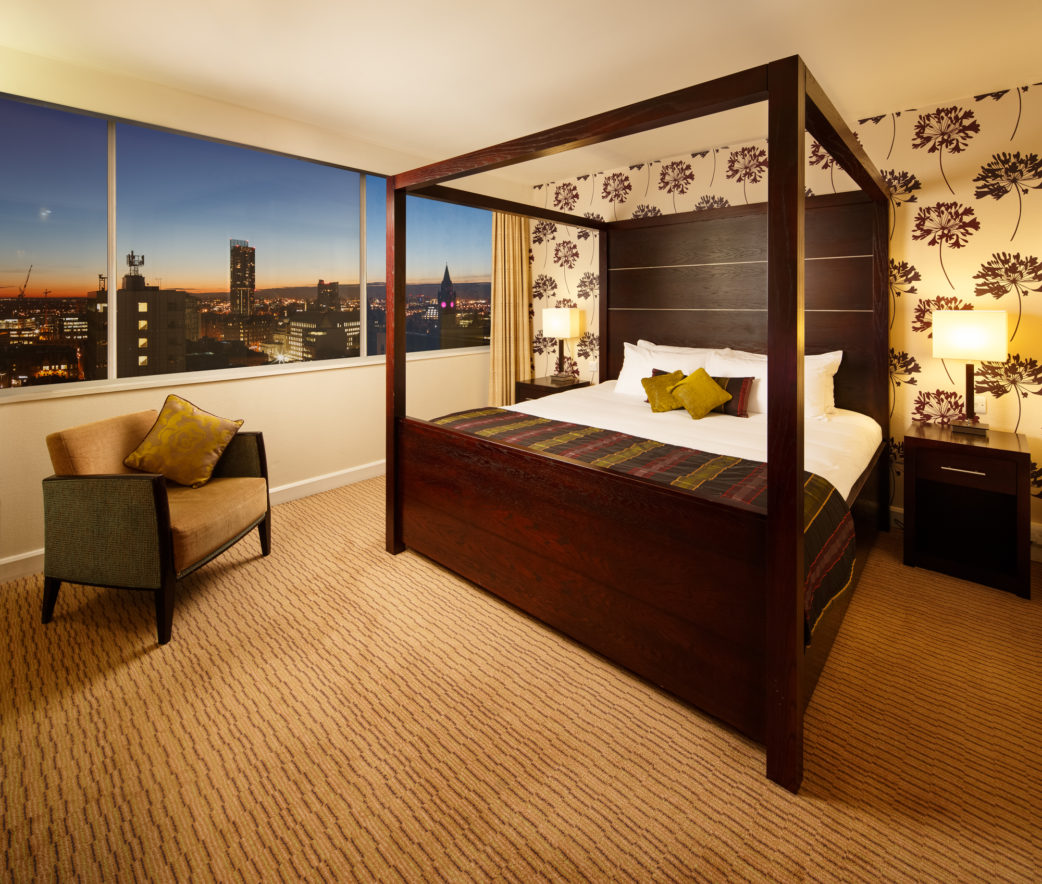 Four poster bed with nighttime picture window view in a superior room at mercure manchester piccadilly hotel