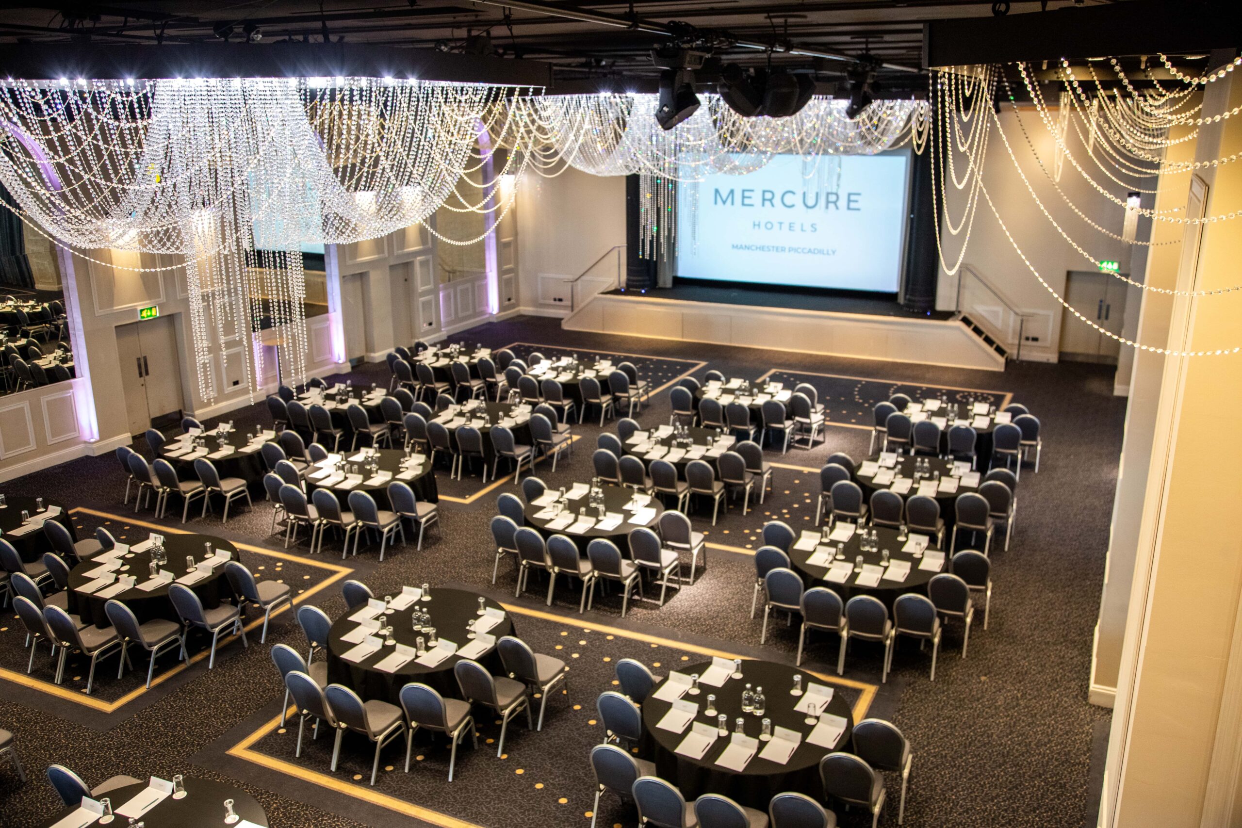 Angled view of The Lakeside Suite at mercure gloucester bowden hall hotel ready for a conference and presentation on the large video screen